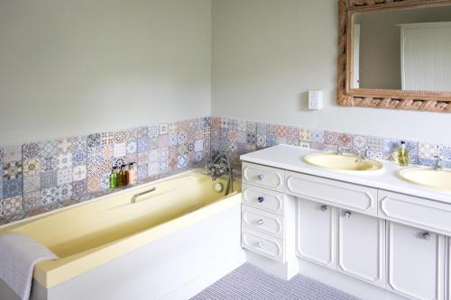 a bathroom with a tub and a sink and a bath tub at Newton Farmhouse B & B in Jedburgh