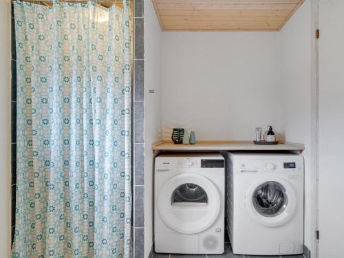 a laundry room with a washing machine and a shower curtain at Holiday Home Daina - 400m to the fjord by Interhome in Vemb