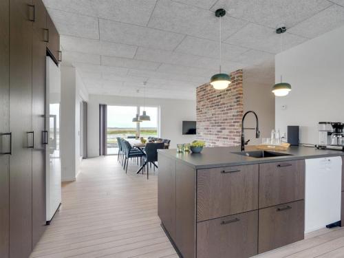 a kitchen with a counter and a dining room at Holiday Home Etje - 6km from the sea by Interhome in Ulfborg