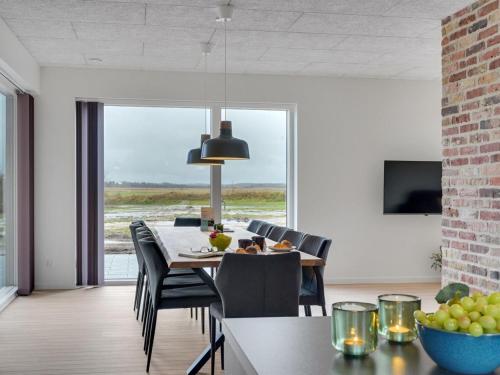 a dining room with a table and chairs and a television at Holiday Home Etje - 6km from the sea by Interhome in Ulfborg