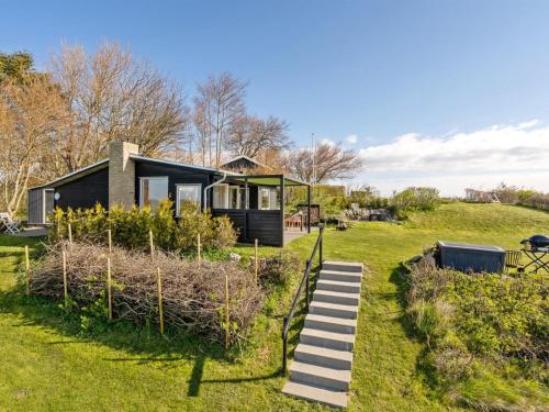a house on a hill with a staircase leading to it at Holiday Home Nielsen - 30m to the fjord by Interhome in Thisted