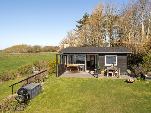 a small cabin in a field with a grass yard at Holiday Home Nielsen - 30m to the fjord by Interhome in Thisted