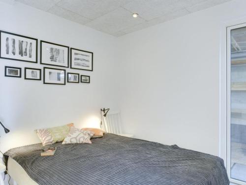 a bedroom with a bed with pillows on it at Holiday Home Herewardus - 10m to the fjord by Interhome in Børkop