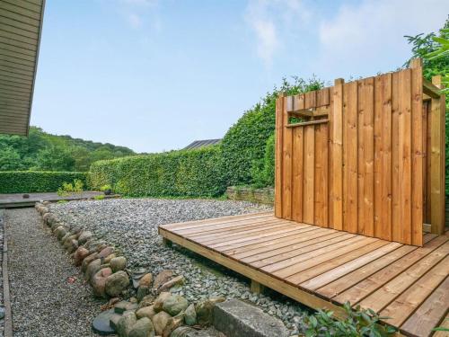 a wooden deck in a yard with a fence at Holiday Home Algot - 100m to the inlet by Interhome in Børkop