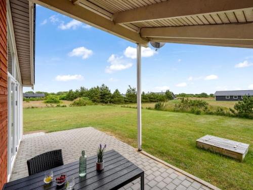 a patio with a table and chairs and a field at Holiday Home Clement - 500m to the fjord by Interhome in Skjern