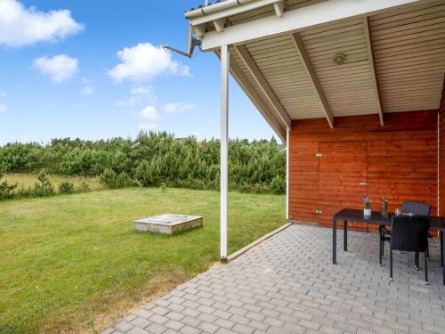 a patio with a table and a field of grass at Holiday Home Clement - 500m to the fjord by Interhome in Skjern