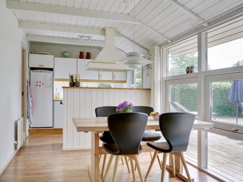 a kitchen with a wooden table and black chairs at Holiday Home Algot - 100m to the inlet by Interhome in Børkop