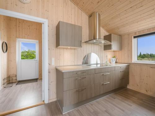 a kitchen with wooden walls and a door with a window at Holiday Home Clement - 500m to the fjord by Interhome in Skjern