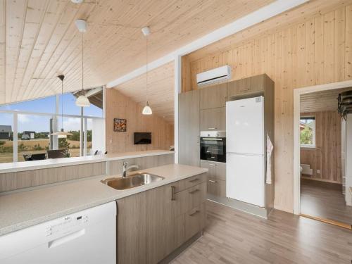 a kitchen with a sink and a large window at Holiday Home Clement - 500m to the fjord by Interhome in Skjern