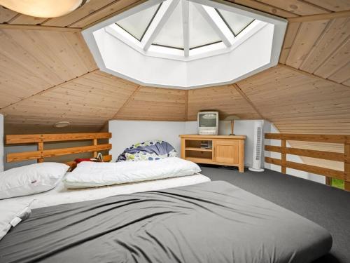 a bedroom with a large bed and a skylight at Holiday Home Reiner - 300m to the fjord by Interhome in Skjern