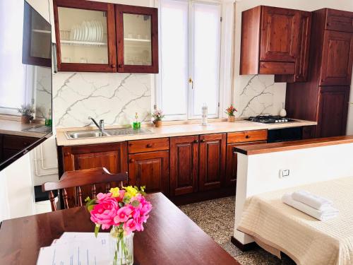 a kitchen with a table with a vase of flowers on it at Maison Du Soleil in Somma Lombardo