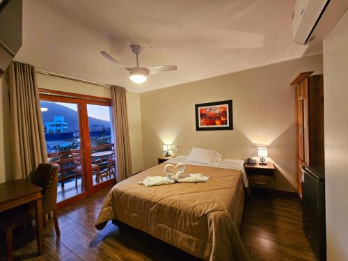 a hotel room with a bed and a balcony at Hotel La Colina in Ica