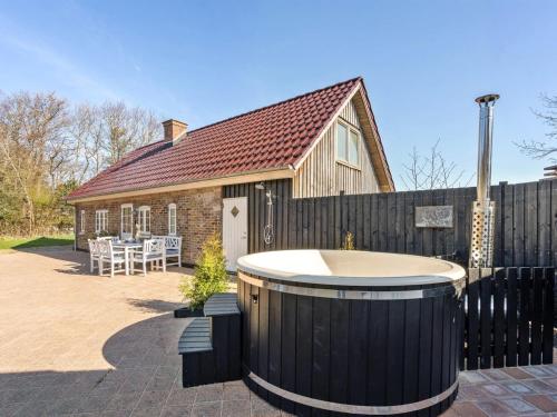a hot tub in a yard next to a house at Holiday Home Malene - 700m to the fjord by Interhome in Ulfborg