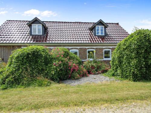 a brick house with bushes in front of it at Holiday Home Malene - 700m to the fjord by Interhome in Ulfborg