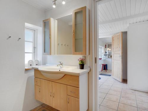 a white bathroom with a sink and a mirror at Holiday Home Malene - 700m to the fjord by Interhome in Ulfborg