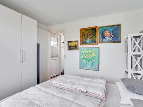 a bedroom with a bed and paintings on the wall at Holiday Home Tomine - 500m to the fjord by Interhome in Struer