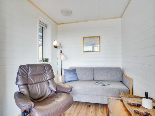 a living room with a couch and a chair at Holiday Home Tomine - 500m to the fjord by Interhome in Struer