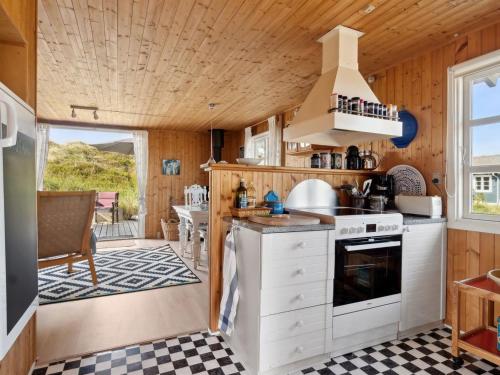 a kitchen in a tiny house with a stove at Holiday Home Wulfhard - 400m from the sea by Interhome in Frøstrup