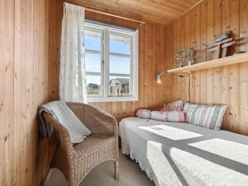 a room with a bed and a chair and a window at Holiday Home Wulfhard - 400m from the sea by Interhome in Frøstrup