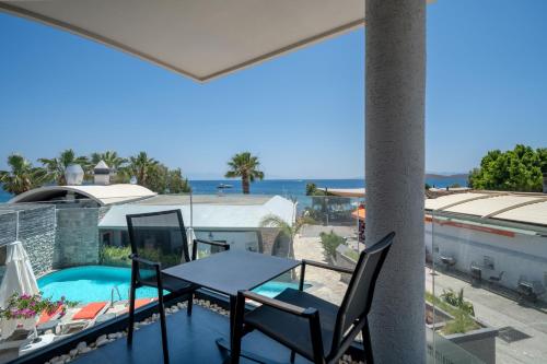 a balcony with a table and chairs and a swimming pool at MyElla Boutique Hotel in Mugla