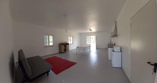 a white living room with a couch and a red rug at Quinta São José in Coruche