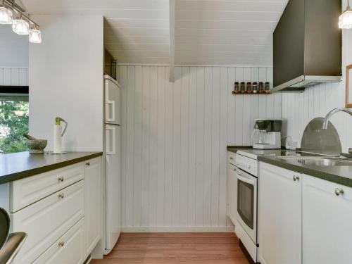 a white kitchen with white cabinets and a sink at Holiday Home Yngve - 56-5km from the sea by Interhome in Give