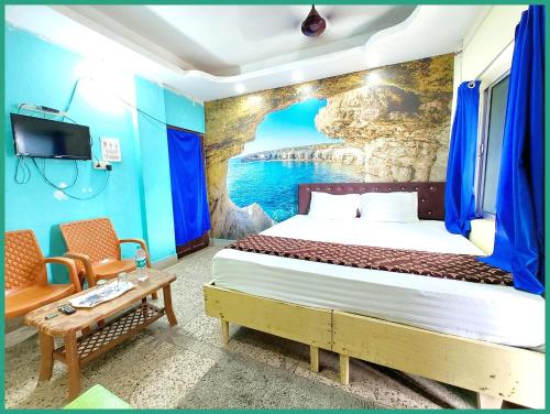 a bedroom with a bed with a painting on the wall at Hotel Nagendra J!K INN Near Sea Beach And Jagannath Temple - Free Public Parking and Wifi Facilities - Air Conditioning Luxury Hotel in Puri