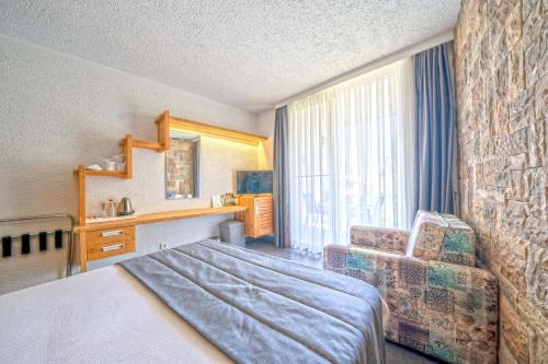 a hotel room with a bed and a chair at MyElla Boutique Hotel in Mugla