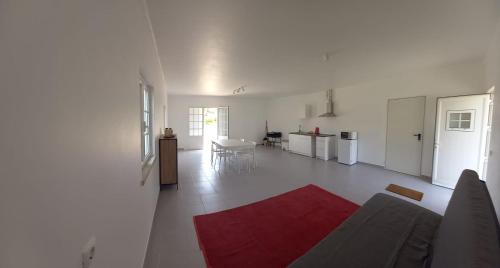 a white living room with a red rug on the floor at Quinta São José in Coruche