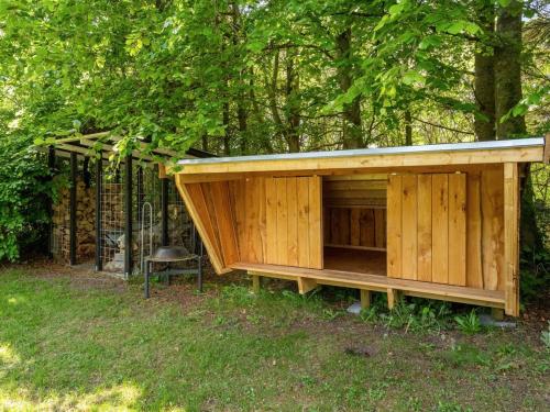 a large woodenshed with a chair in the grass at Holiday Home Ulrike - 600m to the fjord by Interhome in Ulfborg