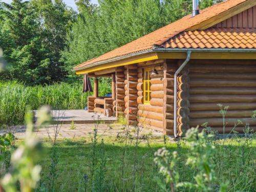 a log cabin with a deck in the yard at Holiday Home Elsia - 1-5km to the fjord by Interhome in Frøstrup