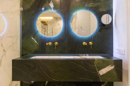 a bathroom with two circular mirrors on the wall at VillaNoa Luxury Stay in Cagliari