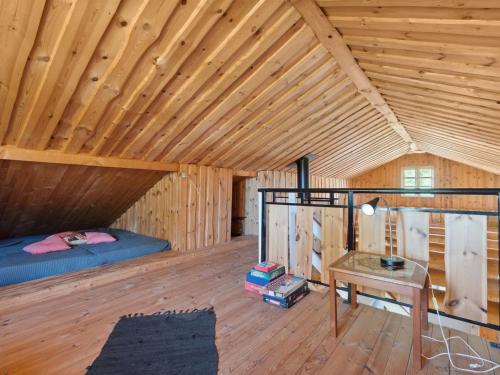 a bedroom in a wooden cabin with a bed and a table at Holiday Home Elsia - 1-5km to the fjord by Interhome in Frøstrup