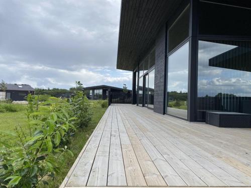 an external view of a house with a wooden deck at Holiday Home Anelle - 500m from the sea by Interhome in Børkop