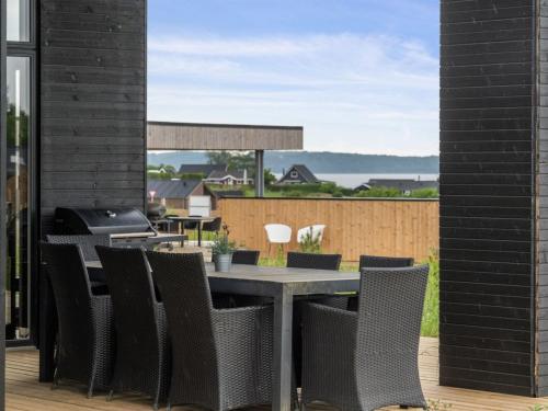 a patio with a table and chairs and a grill at Holiday Home Anelle - 500m from the sea by Interhome in Børkop