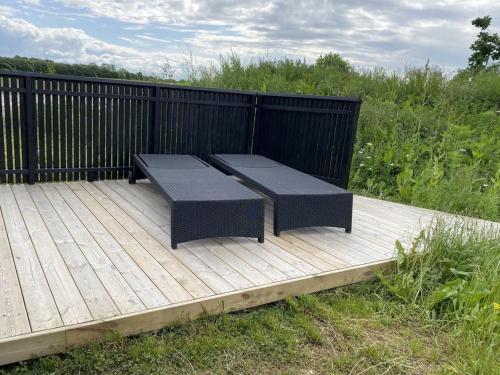 a wooden deck with two benches on top of it at Holiday Home Anelle - 500m from the sea by Interhome in Børkop