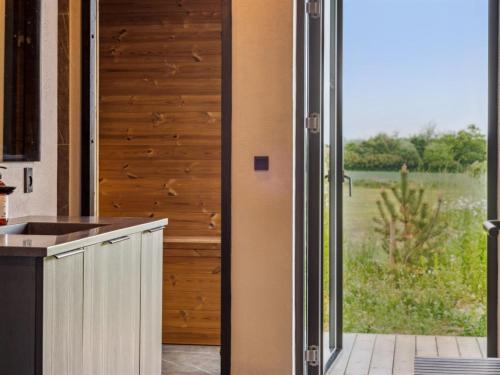 a kitchen with a sliding door with a view of a field at Holiday Home Anelle - 500m from the sea by Interhome in Børkop