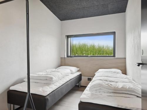 two beds in a room with a window at Holiday Home Anelle - 500m from the sea by Interhome in Børkop