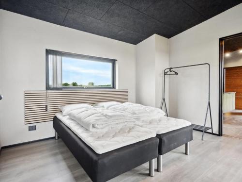 a large bed in a room with a window at Holiday Home Anelle - 500m from the sea by Interhome in Børkop