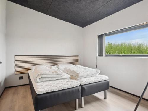 a bed in a room with a window at Holiday Home Anelle - 500m from the sea by Interhome in Børkop