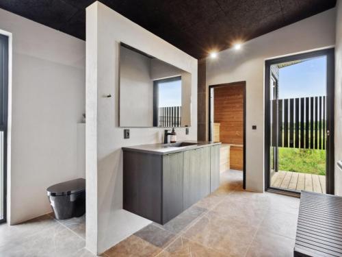 a bathroom with a sink and a mirror at Holiday Home Anelle - 500m from the sea by Interhome in Børkop