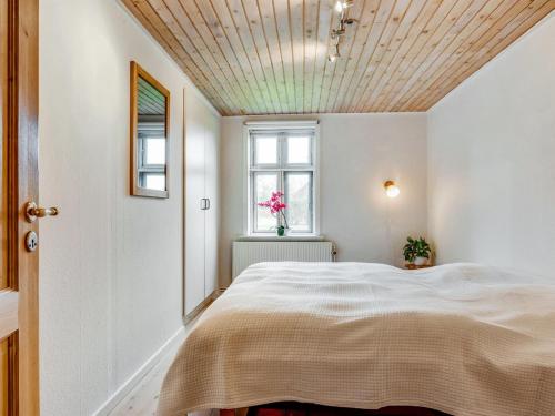 a bedroom with a large bed with a wooden ceiling at Holiday Home Sophia - 8km from the sea by Interhome in Thisted