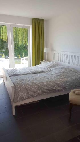 a large bed in a bedroom with a large window at Spatzenhecke in Klütz