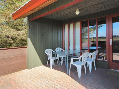a patio with a table and chairs on a porch at Holiday Home Neven - 900m from the sea by Interhome in Torsted