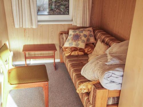 a living room with a couch and a table at Holiday Home Simo - 250m from the sea by Interhome in Øsløs