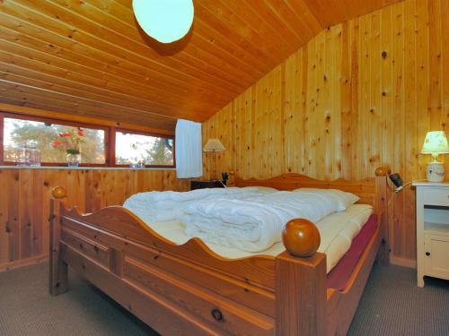 a bedroom with a large bed in a wooden room at Holiday Home Palle - 2km from the sea by Interhome in Snedsted