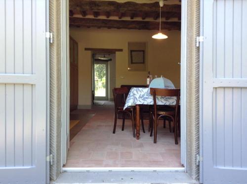 a dining room with a table and chairs and a door at La Doccia in Anghiari