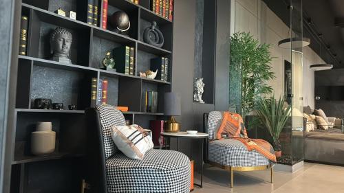 a living room with two chairs and a book shelf at Private Villa for rent in Māḩiş