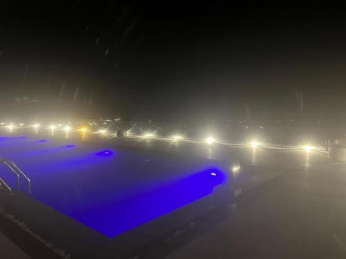 a foggy street with a row of lights at night at Private Villa for rent in Māḩiş
