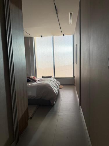 a bedroom with a bed and a large window at Private Villa for rent in Māḩiş